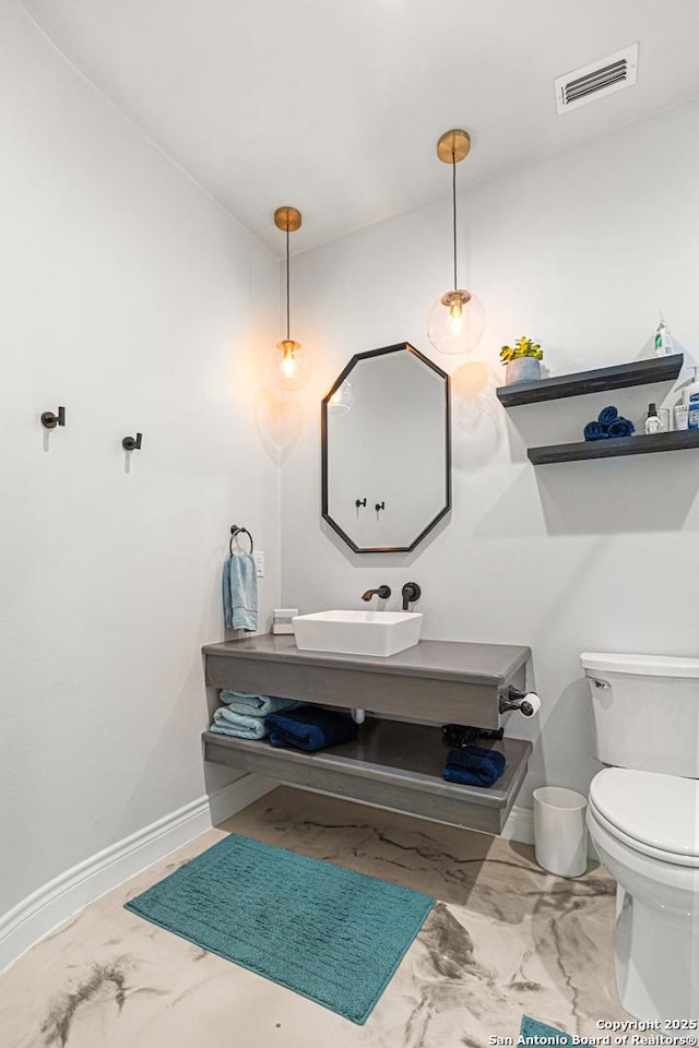 397 County Road 367, Hondo, TX 78861 - half bathroom with marble finish flooring, toilet, baseboards, and vanity