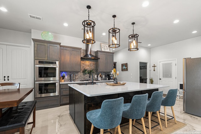 397 County Road 367, Hondo, TX 78861 - kitchen featuring stainless steel appliances, light marble finish flooring, wall chimney range hood, backsplash, and dark brown cabinetry