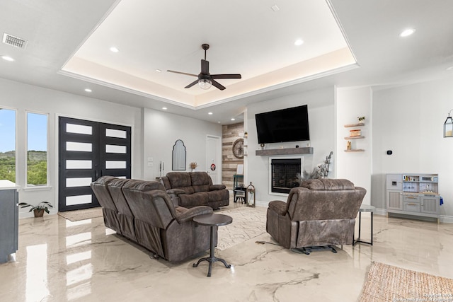 397 County Road 367, Hondo, TX 78861 - living room with light marble finish floors, a tray ceiling, a fireplace, a ceiling fan, and recessed lighting