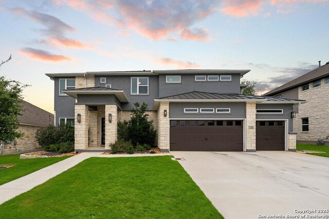 150 Cool Rock, Boerne, TX 78006 - prairie-style house featuring a standing seam roof, stone siding, concrete driveway, a front lawn, and metal roof