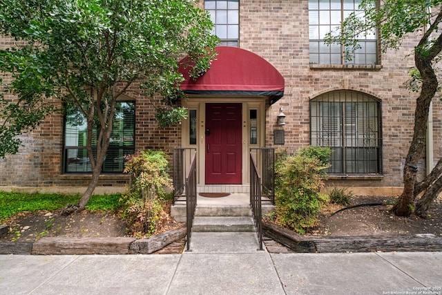 doorway to property featuring brick siding