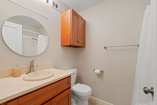 bathroom with toilet, vanity, and baseboards