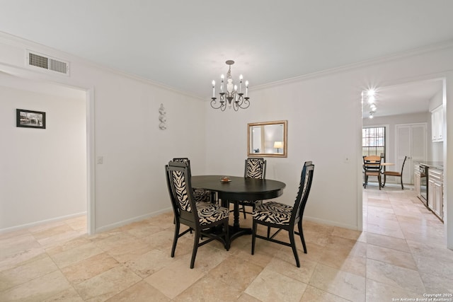 dining room featuring ornamental molding, a chandelier, and baseboards