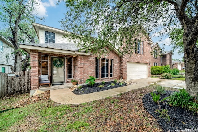view of front of property featuring a garage, fence, driveway, and brick siding