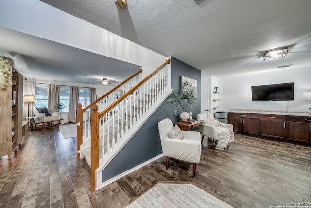 stairway with wood-type flooring, a ceiling fan, and baseboards