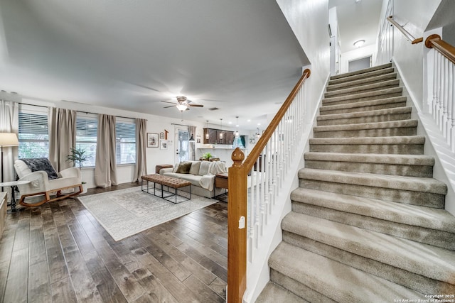 stairs featuring wood finished floors, ceiling fan, and baseboards
