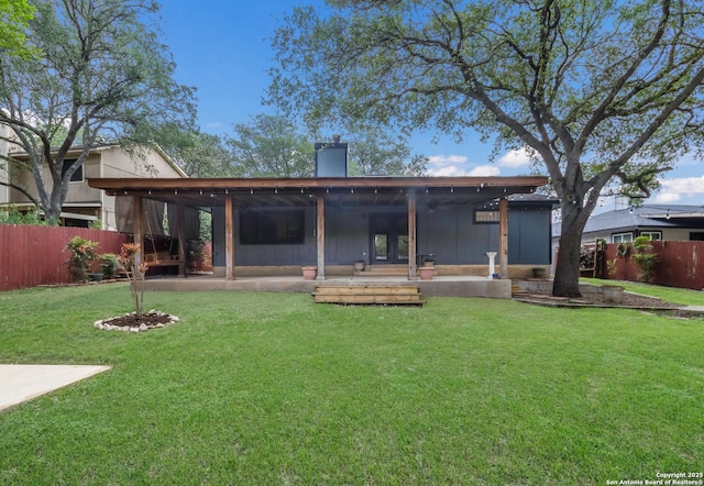 rear view of property featuring a patio area and a chimney