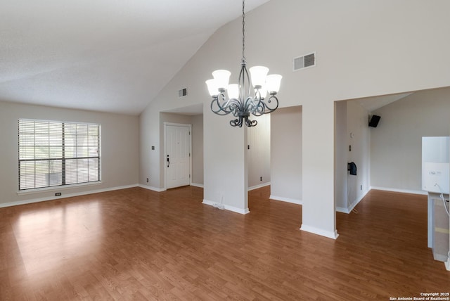 unfurnished dining area featuring high vaulted ceiling, a chandelier, baseboards, and wood finished floors