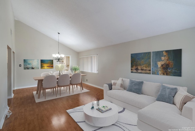 living area featuring a chandelier, wood finished floors, baseboards, and high vaulted ceiling