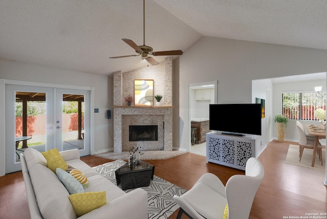 living room featuring french doors, wood finished floors, a ceiling fan, a textured ceiling, and high vaulted ceiling