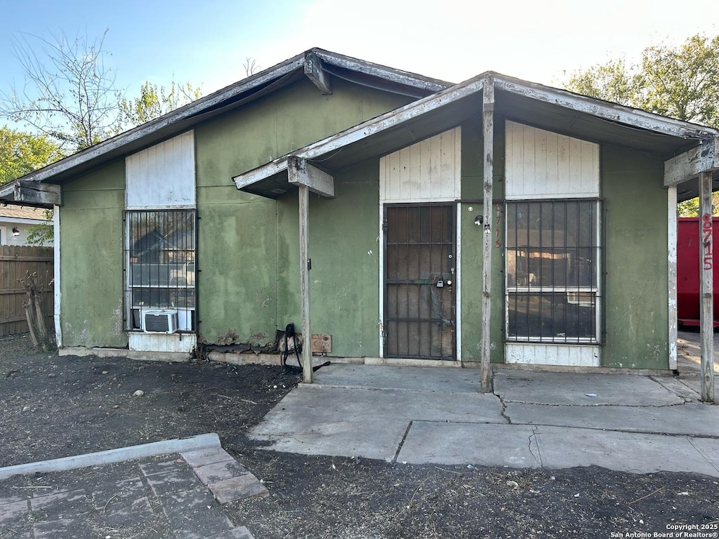 entrance to property with cooling unit and fence