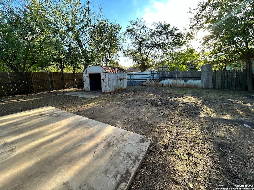 fenced backyard with a storage unit and an outdoor structure