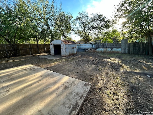 fenced backyard with a storage unit and an outdoor structure
