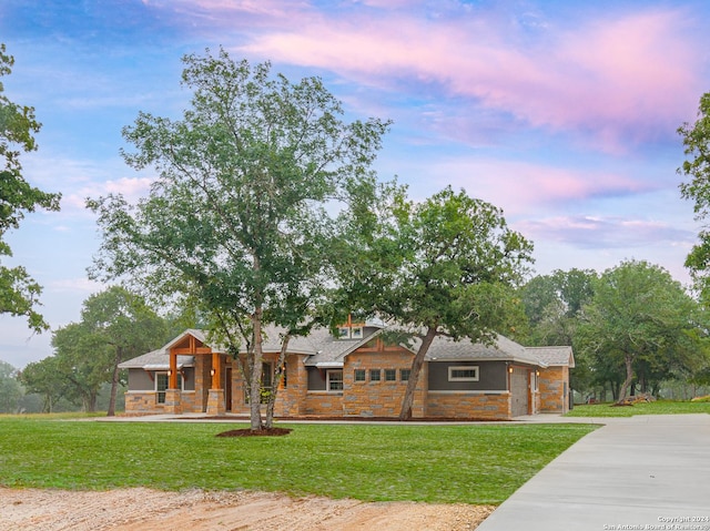 LOT52 Hondo Vis, La Vernia, TX 78121 - view of front facade with stone siding, a porch, driveway, a yard, and an attached garage