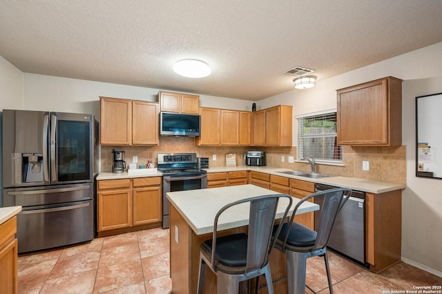 3911 Valencia Peak, San Antonio, TX 78261 - kitchen featuring appliances with stainless steel finishes, a sink, backsplash, light countertops, and a textured ceiling