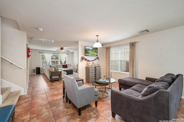 3911 Valencia Peak, San Antonio, TX 78261 - living room featuring a textured ceiling, a ceiling fan, stairs, and light tile patterned floors