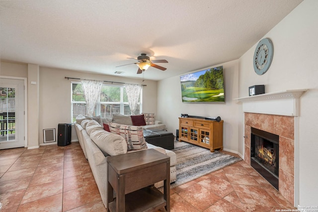 3911 Valencia Peak, San Antonio, TX 78261 - living area with a tiled fireplace, a ceiling fan, a textured ceiling, and baseboards