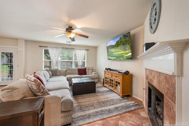 3911 Valencia Peak, San Antonio, TX 78261 - living room featuring ceiling fan, a tile fireplace, a textured ceiling, and baseboards