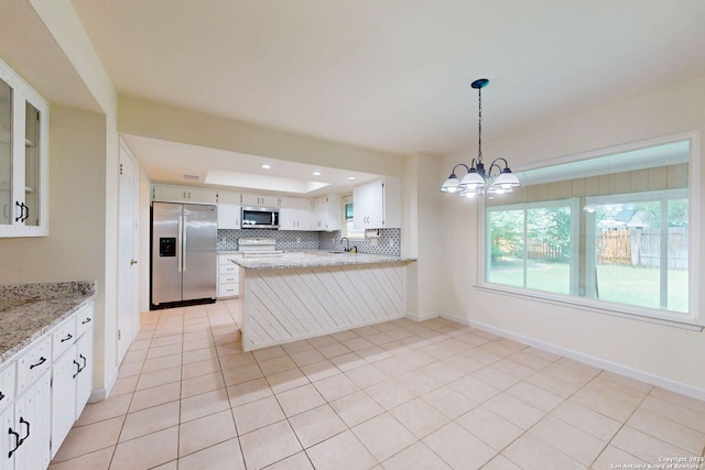 5423 Princess Diane, San Antonio, TX 78229 - kitchen with appliances with stainless steel finishes, a tray ceiling, a chandelier, a sink, and a peninsula