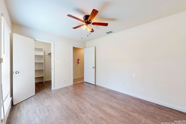 5423 Princess Diane, San Antonio, TX 78229 - unfurnished bedroom with a spacious closet, wood finished floors, baseboards, a ceiling fan, and a closet