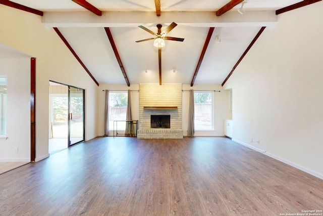 5423 Princess Diane, San Antonio, TX 78229 - unfurnished living room with a ceiling fan, beamed ceiling, wood finished floors, a fireplace, and baseboards