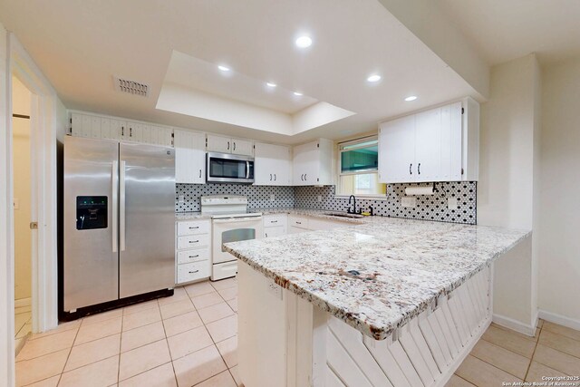 5423 Princess Diane, San Antonio, TX 78229 - kitchen featuring stainless steel appliances, a sink, a peninsula, a raised ceiling, and light tile patterned flooring