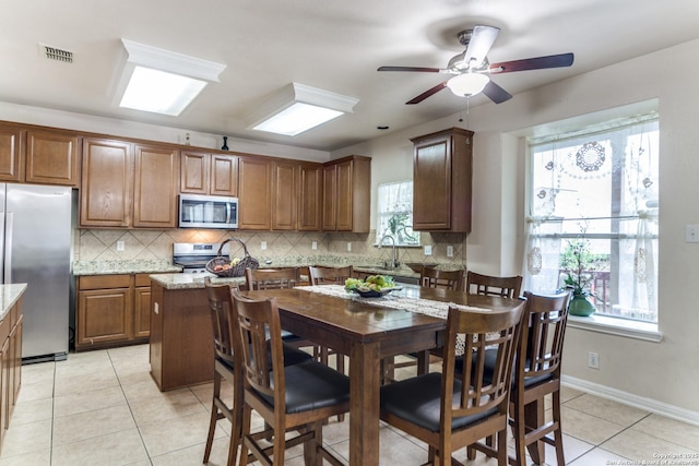 22319 Chimayo, San Antonio, TX 78258 - kitchen featuring appliances with stainless steel finishes, light tile patterned flooring, decorative backsplash, a ceiling fan, and a sink