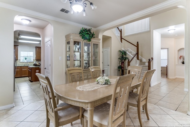 22319 Chimayo, San Antonio, TX 78258 - dining space with arched walkways, light tile patterned flooring, ornamental molding, stairs, and baseboards