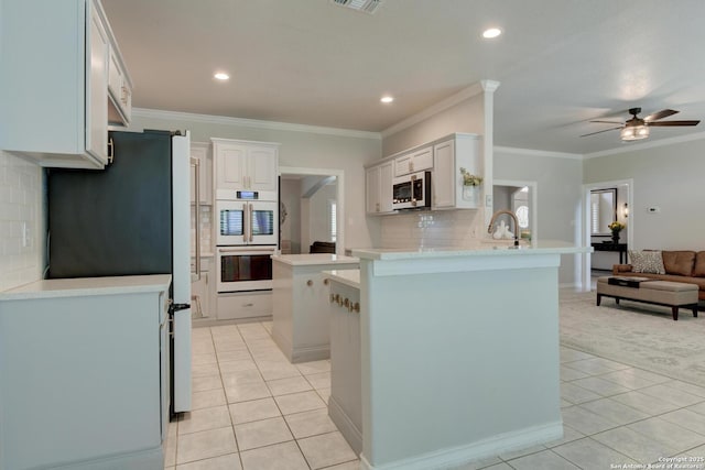 27 Sherborne Wood, San Antonio, TX 78218 - kitchen featuring stainless steel microwave, light tile patterned floors, a peninsula, open floor plan, and ceiling fan
