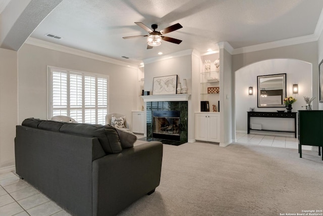 27 Sherborne Wood, San Antonio, TX 78218 - living room featuring ceiling fan, a tiled fireplace, ornamental molding, light carpet, and light tile patterned floors