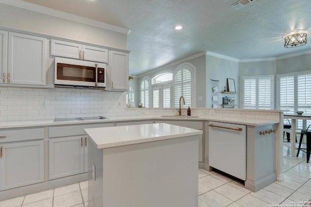 27 Sherborne Wood, San Antonio, TX 78218 - kitchen featuring white appliances, a peninsula, crown molding, a sink, and backsplash