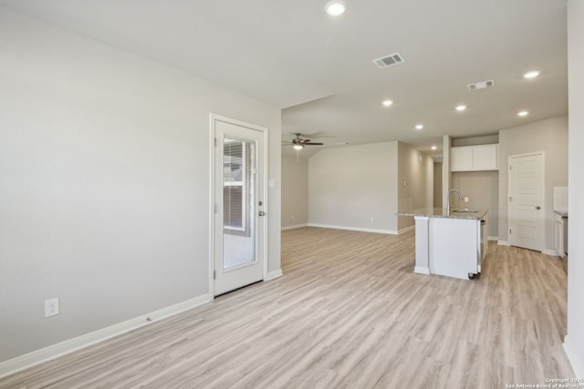 11515 Cottage Pt, San Antonio, TX 78254 - kitchen with ceiling fan, open floor plan, light wood-type flooring, white cabinets, and light stone countertops