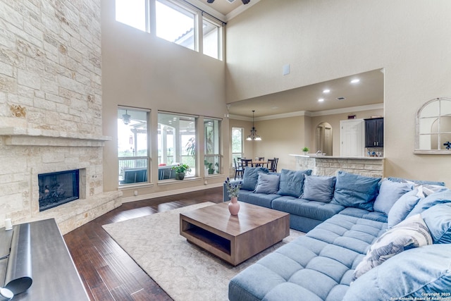 714 Ruidosa Downs, Helotes, TX 78023 - living room with crown molding, plenty of natural light, a towering ceiling, dark wood-style floors, and a stone fireplace