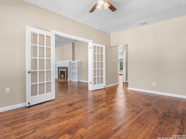 928 W Huisache, San Antonio, TX 78201 - unfurnished living room featuring wood finished floors, a ceiling fan, a warm lit fireplace, and baseboards