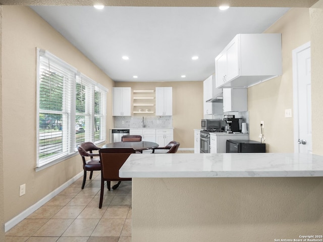 928 W Huisache, San Antonio, TX 78201 - kitchen with white cabinetry, backsplash, appliances with stainless steel finishes, baseboards, and light tile patterned floors