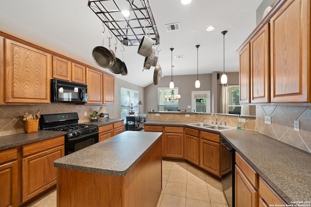 kitchen with black appliances, dark countertops, a sink, healthy amount of natural light, and lofted ceiling