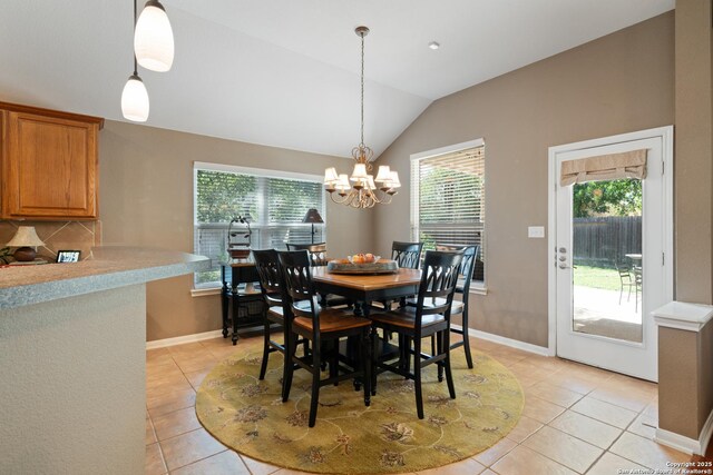 dining area with light tile patterned flooring, a chandelier, lofted ceiling, and baseboards