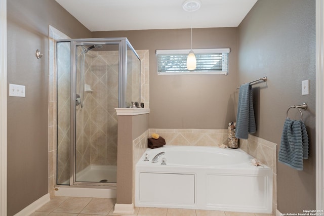 bathroom with a garden tub, a shower stall, tile patterned floors, and baseboards