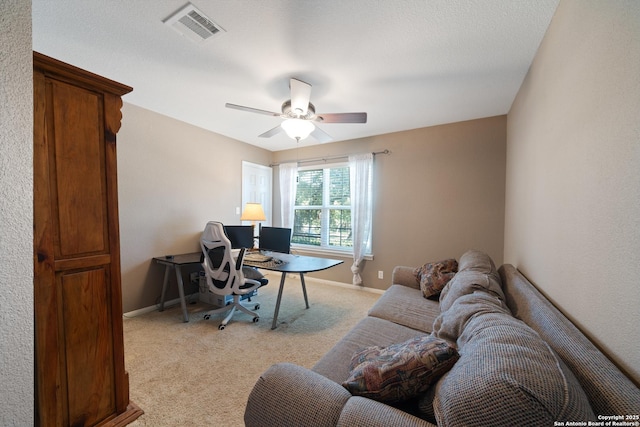 office area featuring light carpet, baseboards, and a ceiling fan