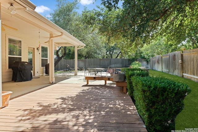 wooden deck with a fenced backyard, grilling area, and outdoor dining area