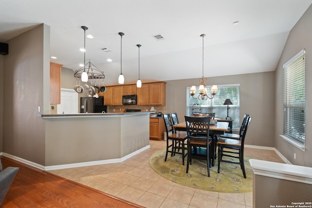 dining room with a chandelier, lofted ceiling, baseboards, light tile patterned floors, and recessed lighting