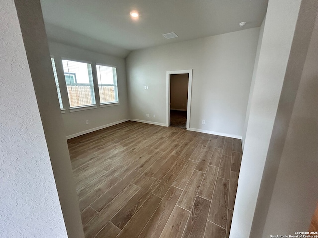empty room featuring wood finished floors and baseboards