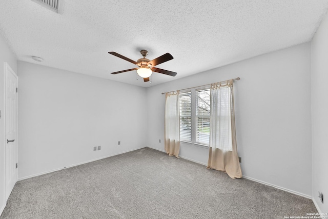 unfurnished room with ceiling fan, carpet floors, a textured ceiling, baseboards, and a smoke detector