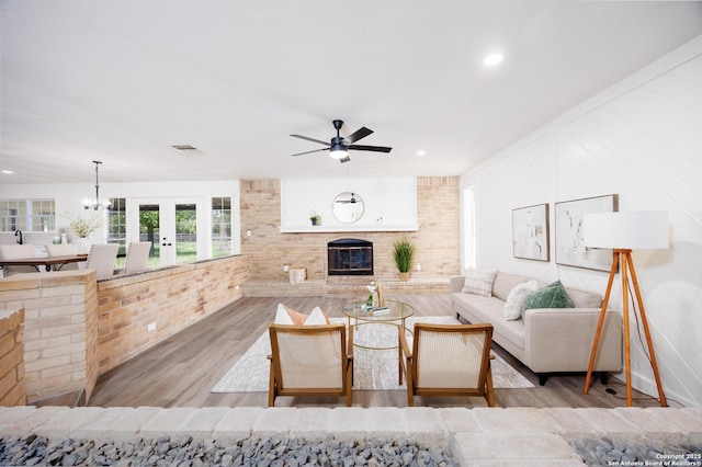 15031 Geronimo, San Antonio, TX 78254 - living room with a fireplace, wood finished floors, ceiling fan, a chandelier, and recessed lighting