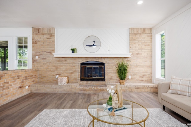 15031 Geronimo, San Antonio, TX 78254 - living room with healthy amount of natural light, wood finished floors, a fireplace, a ceiling fan, and brick wall