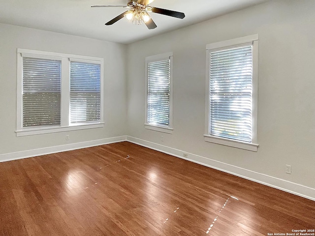 unfurnished room with wood finished floors, baseboards, and ceiling fan