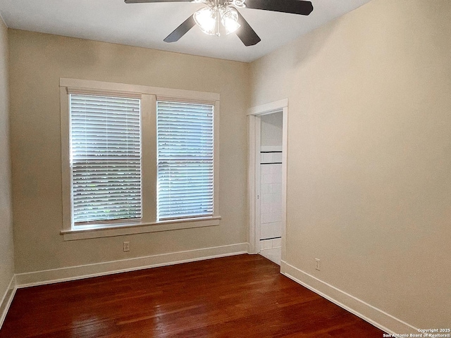 unfurnished bedroom featuring dark wood-style floors, baseboards, and a ceiling fan