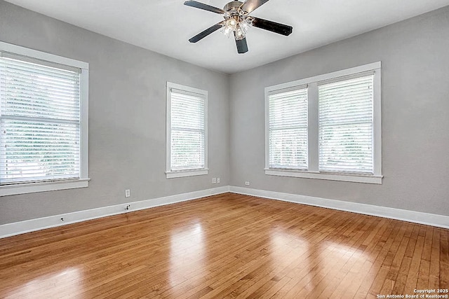 spare room with hardwood / wood-style flooring, baseboards, and ceiling fan