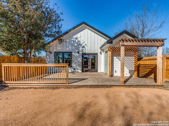 back of house with a wooden deck, french doors, board and batten siding, fence, and a pergola