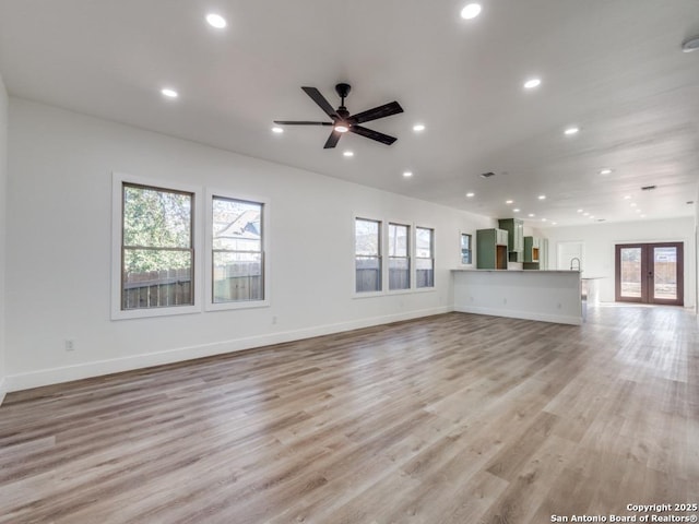 unfurnished living room with plenty of natural light, recessed lighting, a ceiling fan, and light wood-type flooring